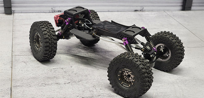 Custom RC crawler chassis with titanium links and purple shocks, built for extreme articulation and precision crawling by RCSTEVE.