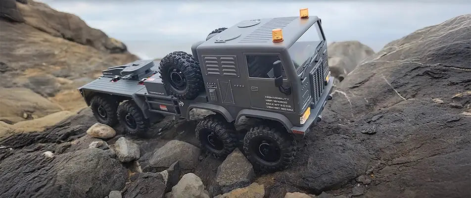 RC 6x6 tactical truck crawling over rocks, showcasing RCSTEVE off-road performance and durability with high-traction tires and scale detail.