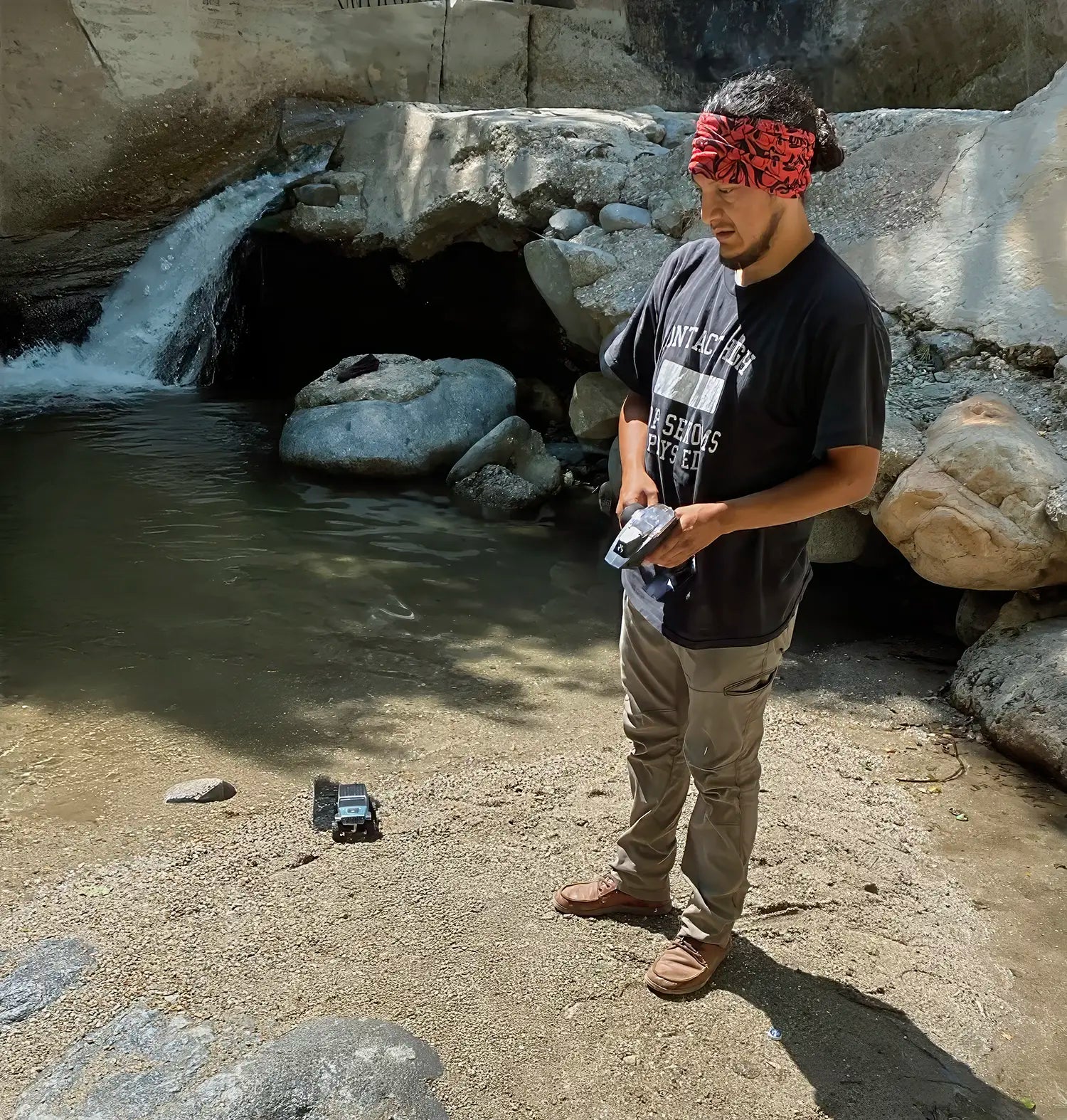 RCSTEVE founder operating an RC crawler near a waterfall, showcasing hands-on testing of performance parts and real-world crawling in natural terrain.