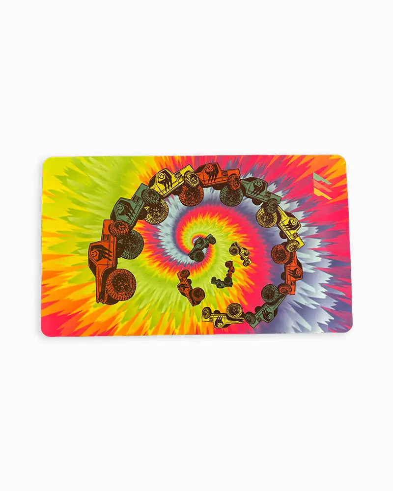 RCSTEVE tie-dye desk mat featuring a spiral of colorful RC crawlers on a red, yellow, blue, and green background — a bold design celebrating creativity and off-road passion.